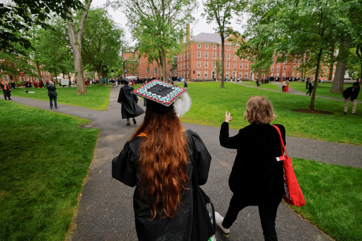 人们步行前往参加在美国马萨诸塞州剑桥市举行的哈佛大学第 374 届毕业典礼 ...